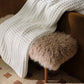 Cozy throw blanket on faux fur bench, White