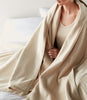 Woman wrapped in Favorite Reversible Cotton Blanket in Linen color