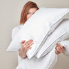 woman holding white goose down bed pillow inserts