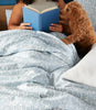 Woman in Bed Reading a Book with Dog and Fern Duvet Cover in Denim