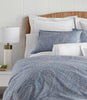 Blue paisley pillow shams and duvet cover on bed